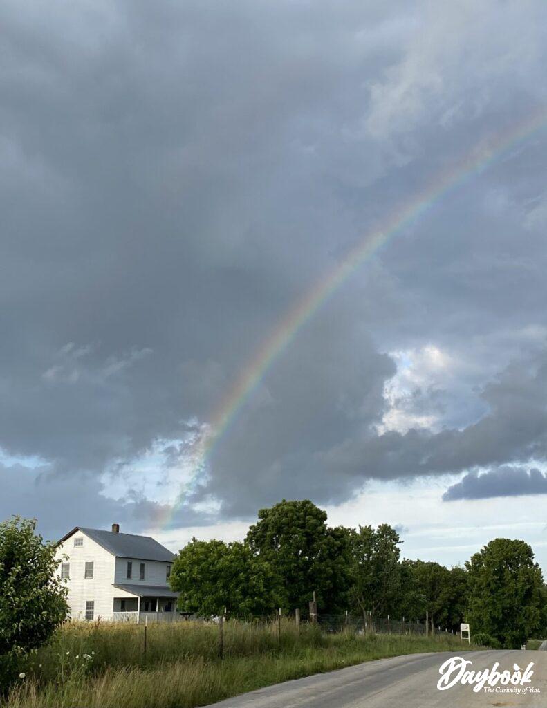 Amish house with rainbow in sky