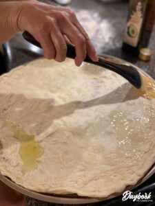 pizza dough being brushed with avocado oil