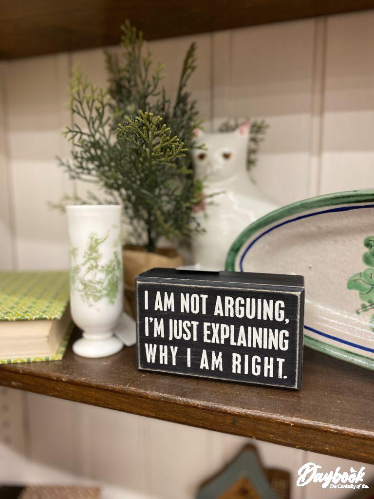 display of antique book, vase, cat figurine and sign
