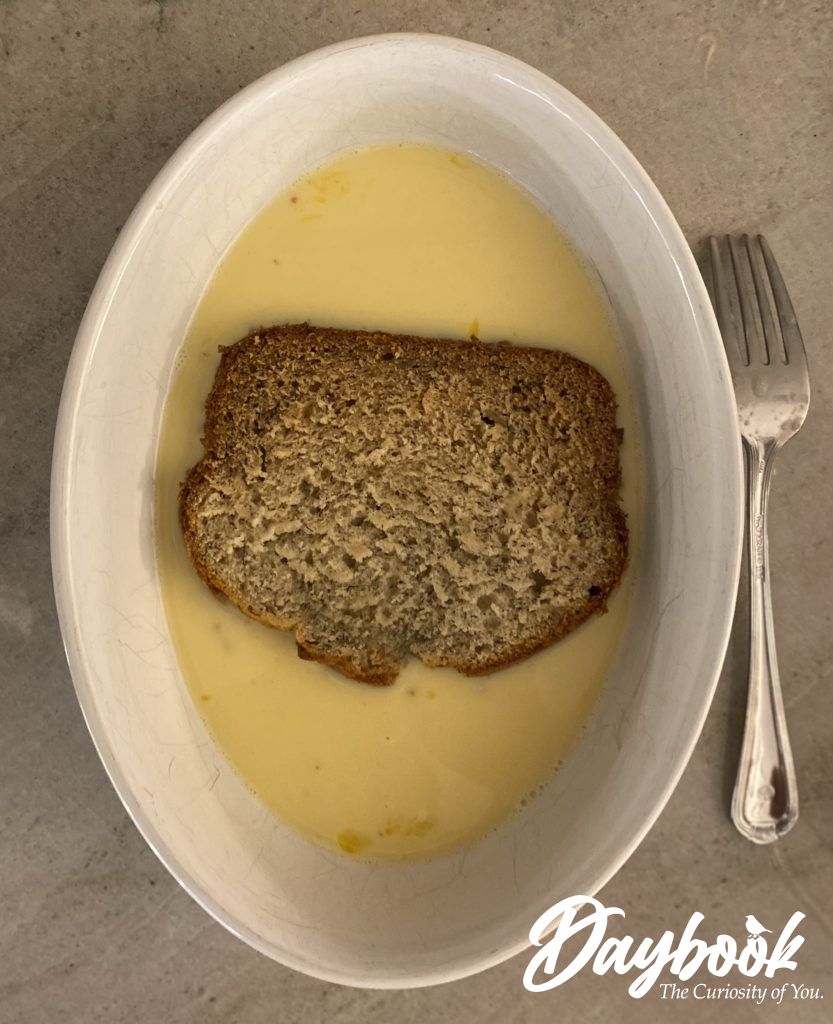 one slice of banana bread soaking in an egg and milk mixture