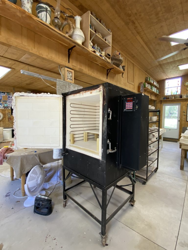 A large kiln in a potter's workspace.