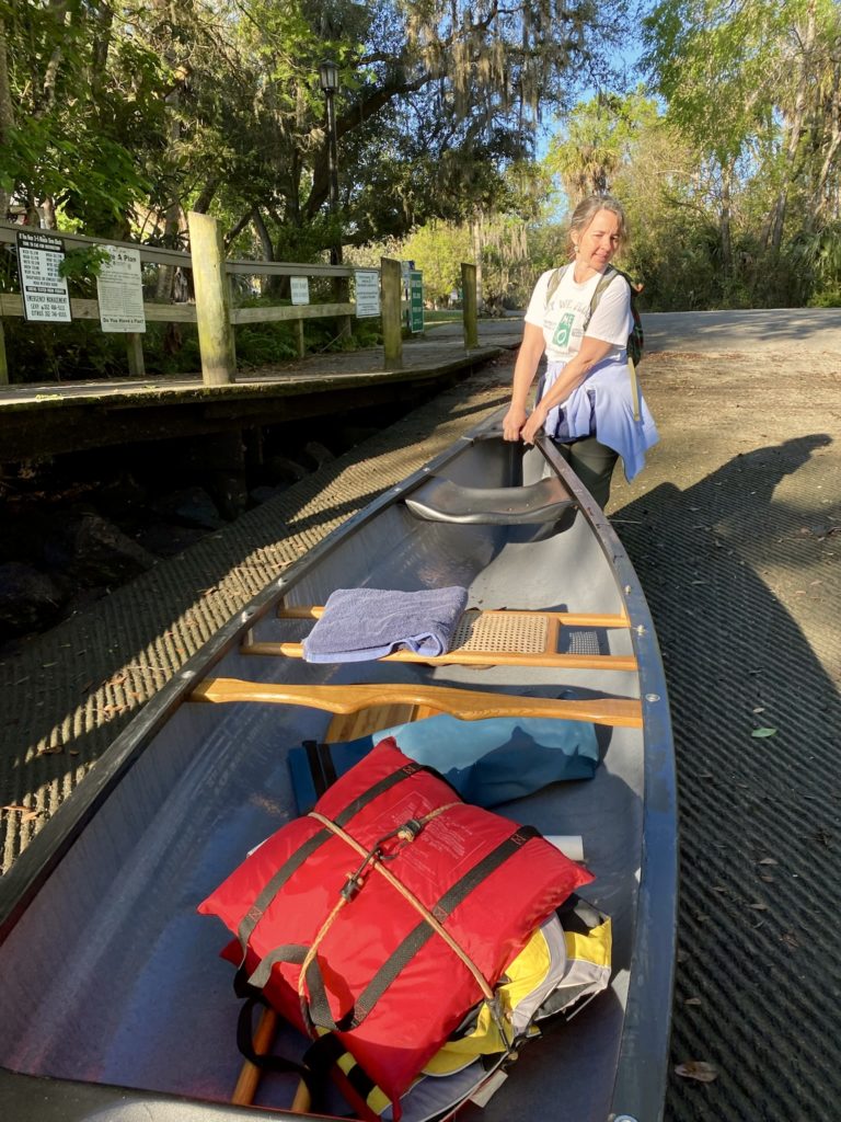 Kristy pulling our new canoe out of the water at the boat ramp.