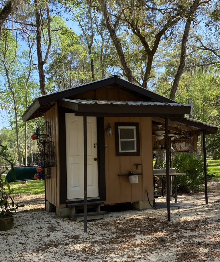 A potter's shed with a small covered area on the front and side.