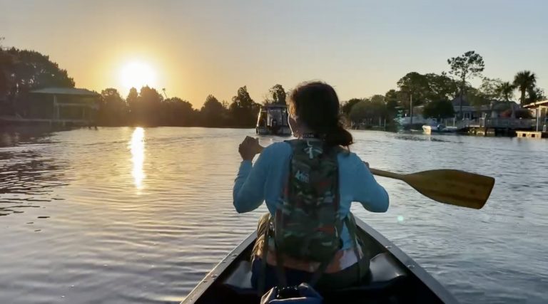 Kristy paddling our new canoe in Florida at sunrise