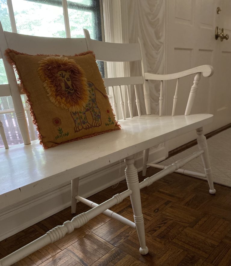 A white bench inside a home's foyer.