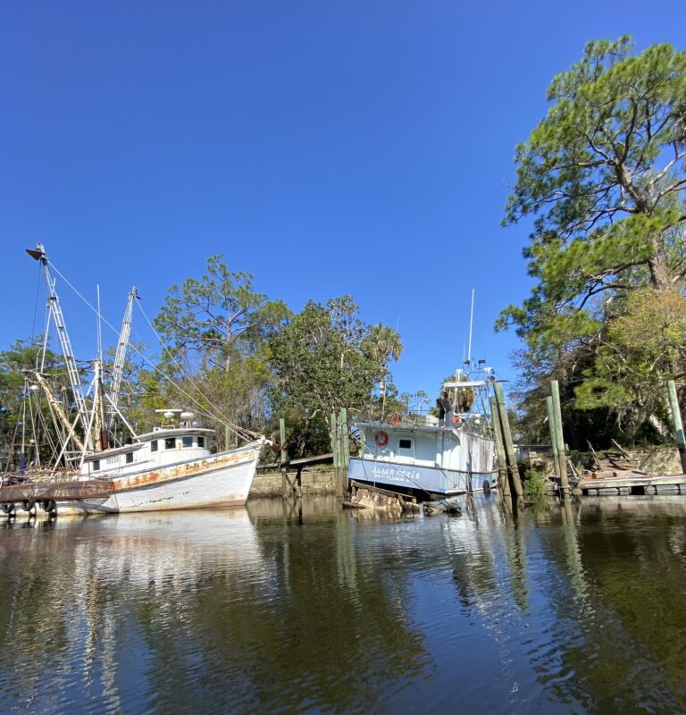 Two large boats anchored by river docks