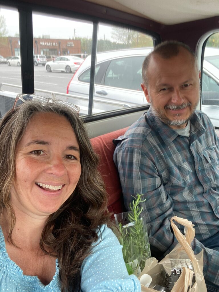 Man and woman driving a 70's white Silverado truck on a Sunday afternoon