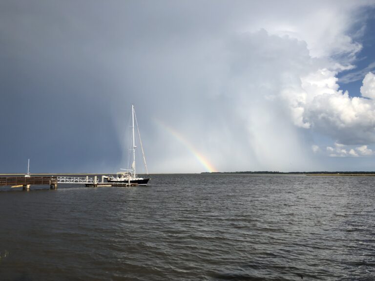 rainbow in the sky over the ocean as the storm runs out of rain